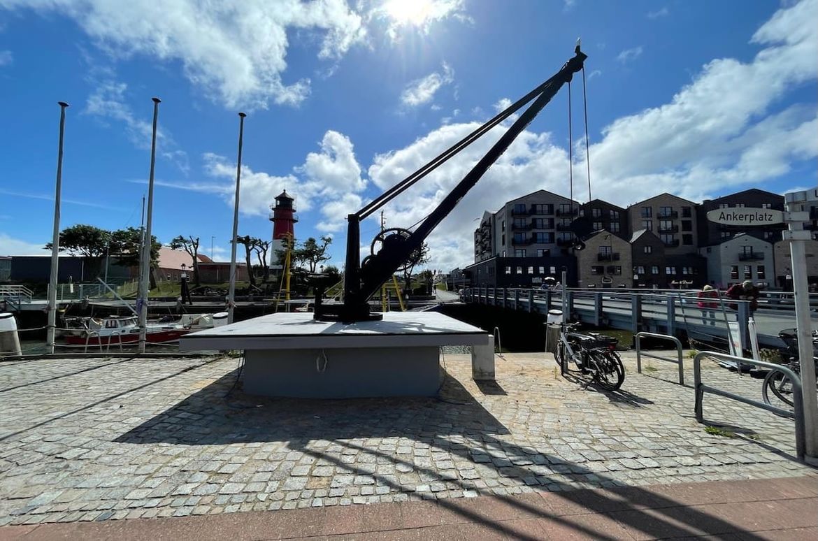 antiker Kran auf dem Ankerplatz mit Muesumshafen und Leichtturm